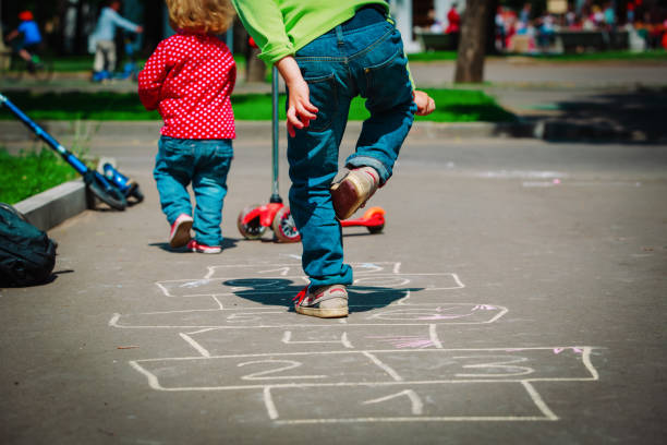 istock kids playing hopscotch on playground 954569898