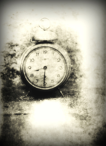 Old photo of the alarm clock - grained, scratched, overexposure and underexposure, unfocused