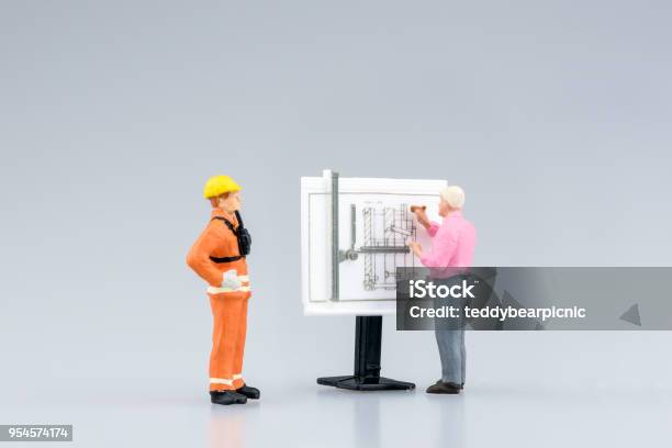 Miniature Engineering People And Architecture Working On Construction Drawing Stock Photo - Download Image Now