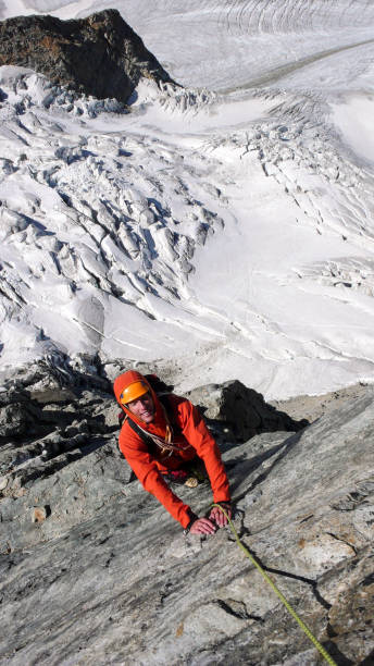 alpiniste mâle sur une voie d’escalade exposée au-dessus d’un glacier - piz palü photos et images de collection