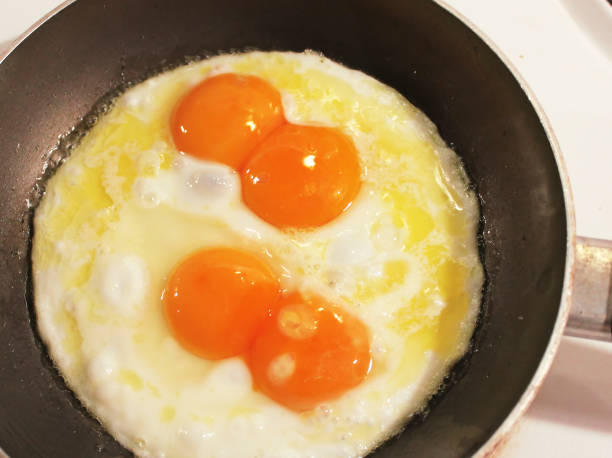 double yolk eggs fried in fresh butter stock photo