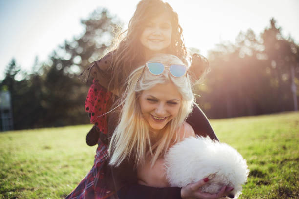 istock happy mother and daughter with poodle dog. 954592324