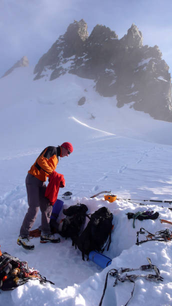 istock mountain climber getting ready for a cold bivouac night in a snow hole on a glacier in the Alps 954592420