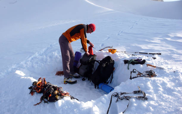 istock mountain climber getting ready for a cold bivouac night in a snow hole on a glacier in the Alps 954597130