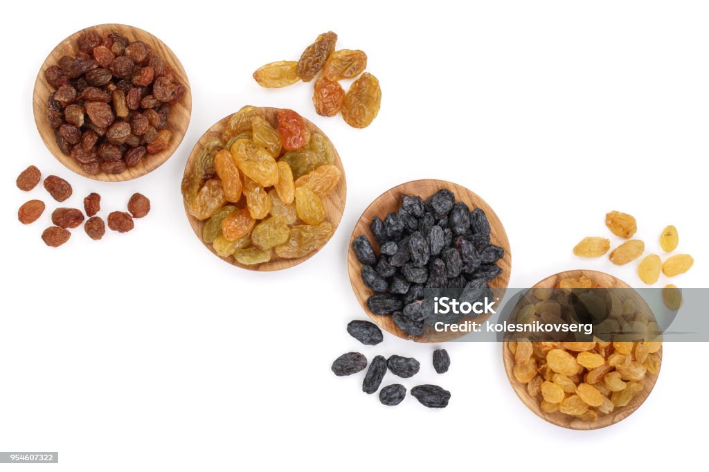 Collection of raisins in wooden bowl isolated on a white background with copy space for your text. Top view. Flat lay Collection of raisins in wooden bowl isolated on a white background with copy space for your text. Top view. Flat lay. Arid Climate Stock Photo