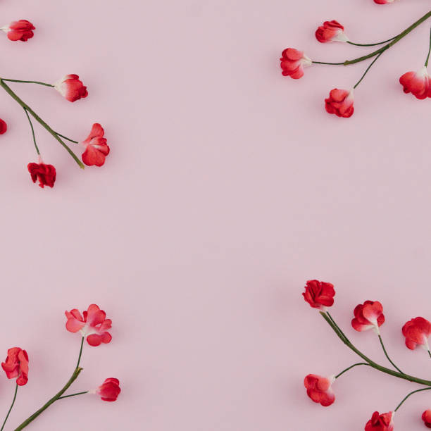 istock Red paper flowers with branch on pink background with copy space 954610690