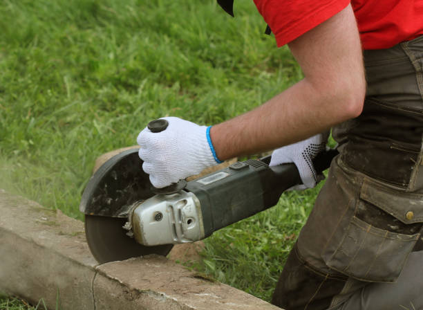 istock Construction worker cutting concrete plate for fence foundation using a cut-off saw 954620080