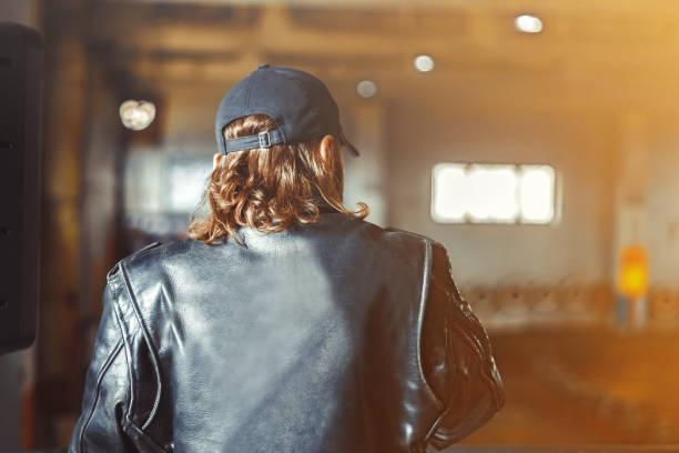 man in leather jacket A young man in a leather jacket and cap on the back larrikin stock pictures, royalty-free photos & images