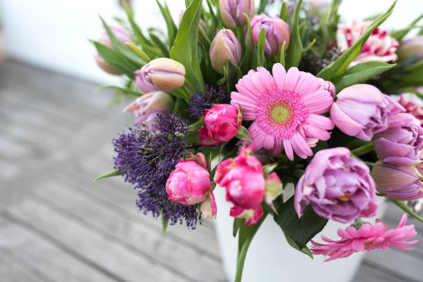 Colorful mothers day bouquet in a vase on gray vintage planks