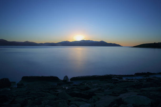 A sunset afterglow over Mount Brandon and The Maheree Islands which lay off Irelands West Coast on a winters evening with a flat calm Atlantic Ocean, part of Irelands Wild Atlantic Way.