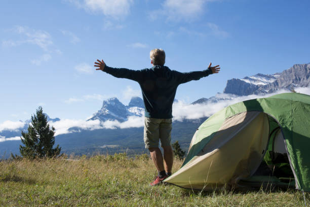 istock Man enjoys camping on a mountain meadow 954624748