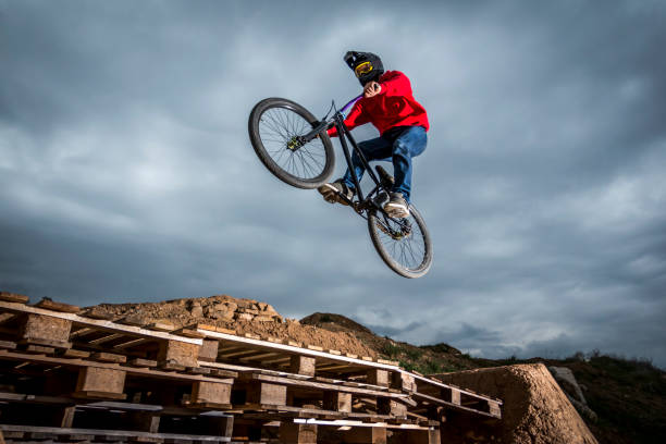 istock Young man jumping over hole in dirtjump circuit 954630872