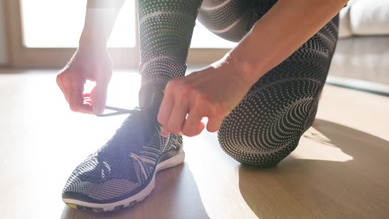 Woman tying shoelaces on sports shoe