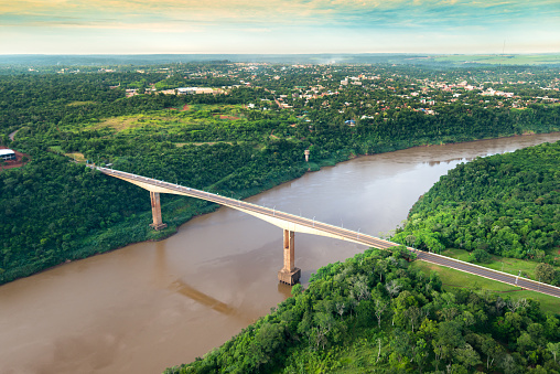 Aerial view of The Tancredo Neves Bridge, better known as Fraternity Bridge connecting Brazil and Argentina through the border over the Iguassu River, with the Argentinian city of Puerto Iguazu in the back.