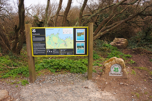 A National Trust sign displaying a map and information at Porthcurno, Cornwall, UK.