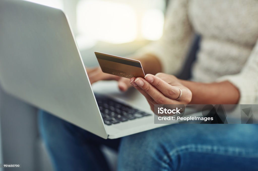 The most comfortable place to make payments Shot of an unrecognizable woman making payments online with a credit card at home Credit Card Stock Photo