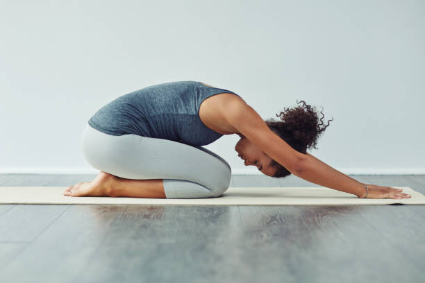 Achieving sound of mind through yoga Studio shot of an attractive young woman practicing yoga against a grey background childs pose stock pictures, royalty-free photos & images