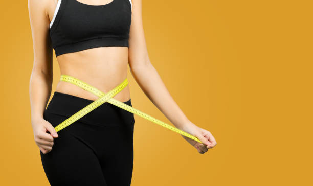 istock Slim young woman measuring her waist 954651114