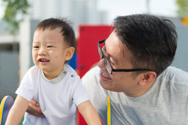 istock Asian father with his little boy at playground 954651602