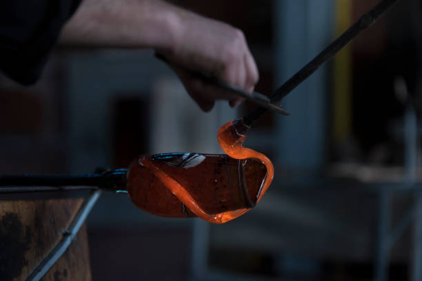 istock Glassblowing worker cutting liquid glass 954661612