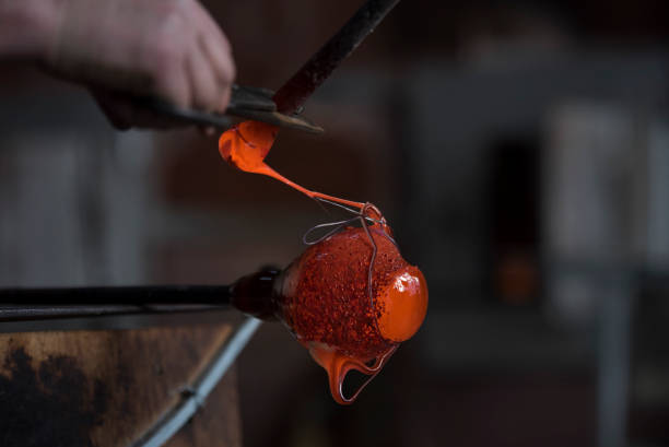 istock Traditional glassblowing worker cutting liquid glass 954661840