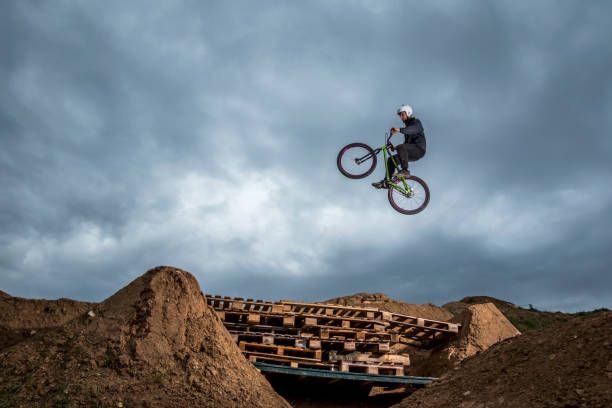 istock Young man jumping over hole in dirtjump circuit 954665536