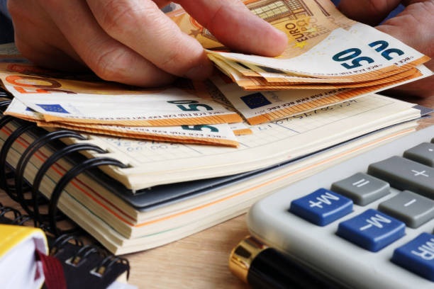 istock Man counting euro banknotes. Desk with calculator, ledger and euros. 954666496