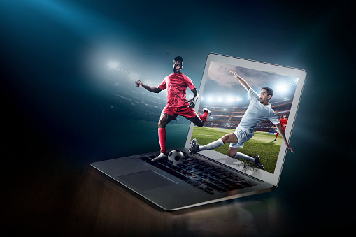 Soccer game on laptop. Live broadcast. Laptop on the table with football game that came to life. Athlete scores a goal