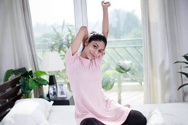 Beautiful woman stretching on bed