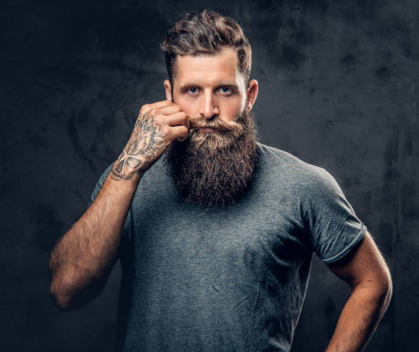 istock A man touches his moustache over grey background. 954675990