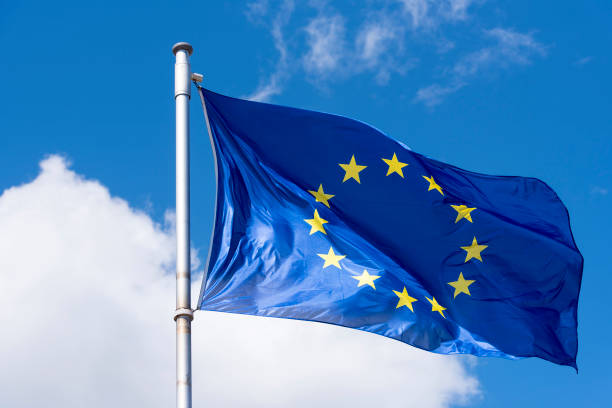 eu-flagge winken gegen blauen himmel - europäische union stock-fotos und bilder