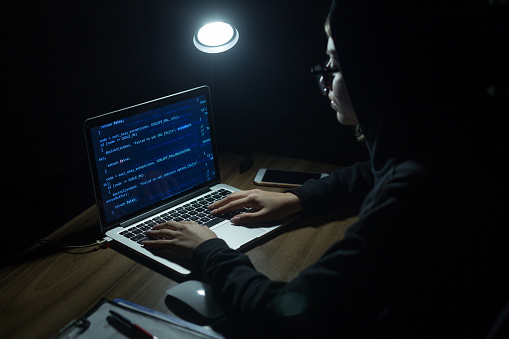 Hacker de joven con capucha haciendo ataque cibernético photo