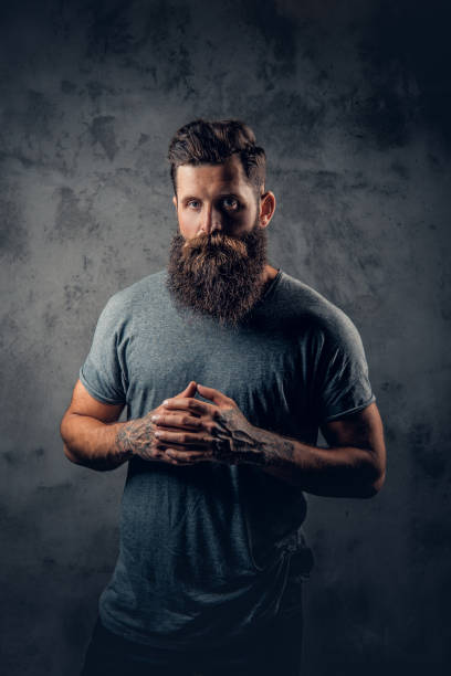 istock A man with tattooed arms over dark grey background. 954686474