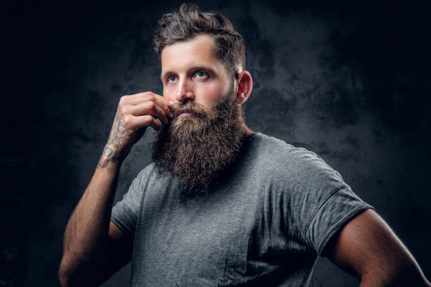 istock A man touches his moustache over grey background. 954686974