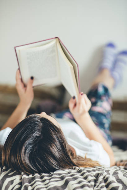 istock Woman relaxed in bed after a busy day reading a book. 954695840