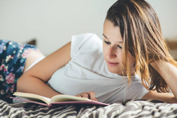 istock Woman relaxed in bed after a busy day reading a book. 954695966