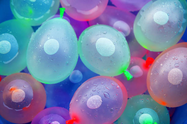 Plastic container full with balloons filled with water, ready for water bomb children  fun in the yard.