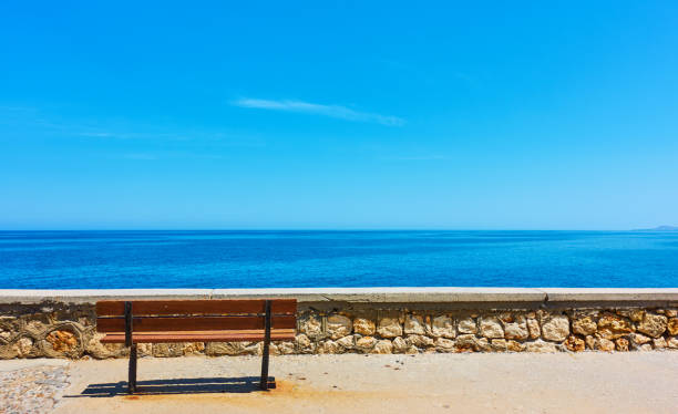 istock Lonely bench near blue sea 954696920