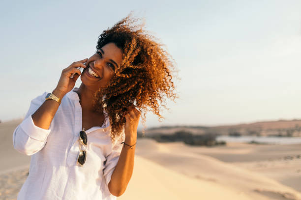 istock Curly black girl using phone 954697022