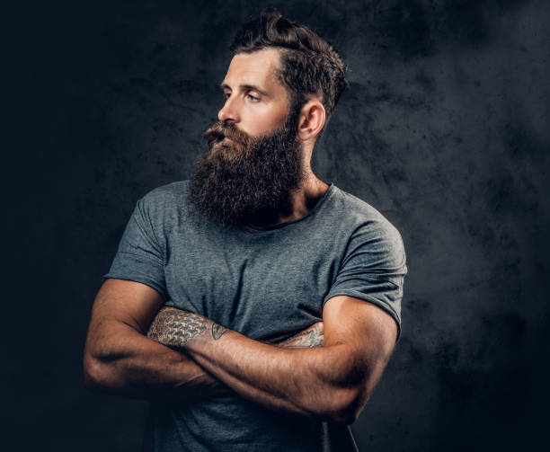 istock Bearded male with tattoos on arms over grey background. 954697146