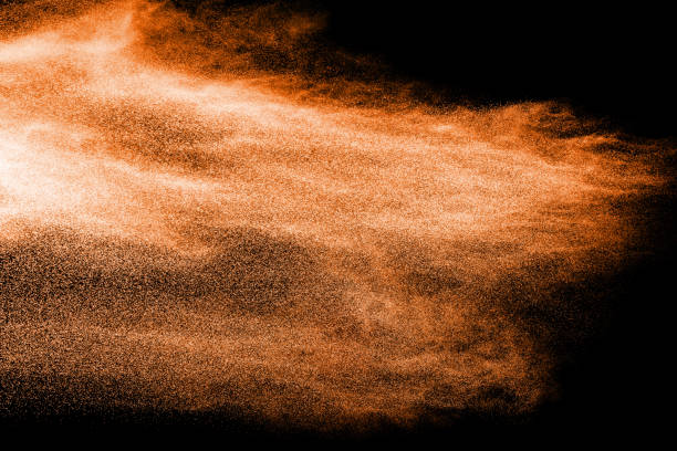 istock abstract orange dust explosion on  black background. abstract orange powder splattered on black background, Freeze motion of orange powder splash. 954700362