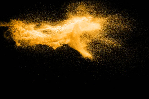 istock abstract orange dust explosion on  black background. abstract orange powder splattered on black background, Freeze motion of orange powder splash. 954700390