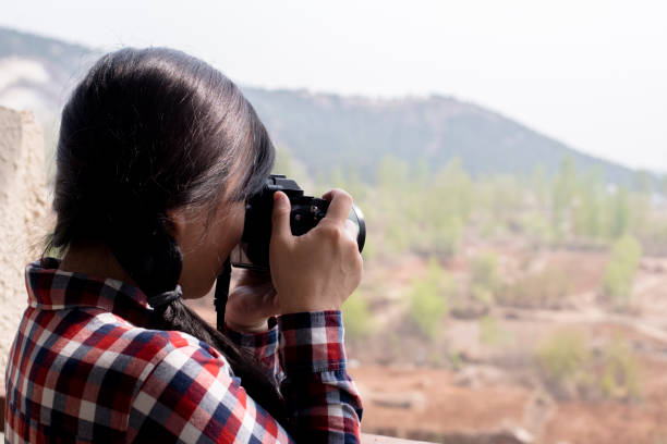 istock girl taking pictures with camera on balcony 954700644