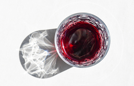 Red wine in glass on white background with shadow