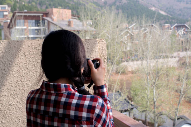 istock girl taking pictures with camera on balcony 954702898