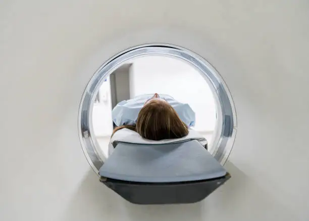 Unrecognizable female patient lying down ready for an MRI exam at the hospital
