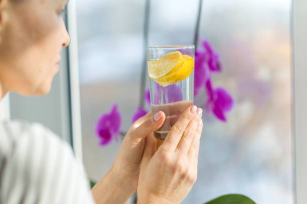 istock Woman drinking water with fresh organic lemon. 954716960