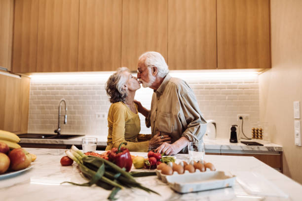 istock senior couple kissing on the kitchen 954718002