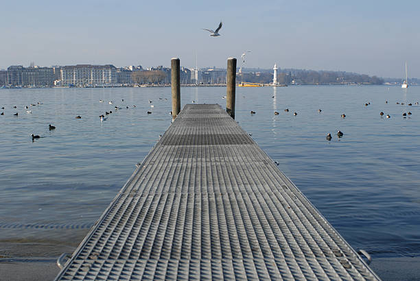 Entrance to Lausanne Ouchy harbour on Lake Geneva on overcast stormy day with mountains in backdrop