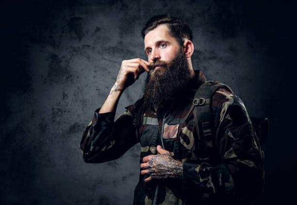 istock Bearded tattooed male in camouflage jacket. 954722314